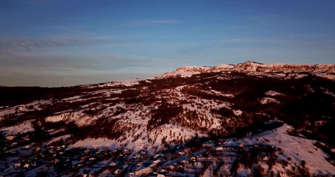 Aerial panoramic view of the village snow capped mountains during sunrise in Psebai, Russia
