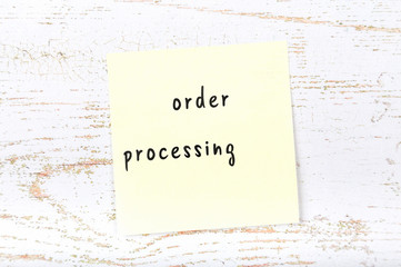 Yellow sticky note with handwritten text order processing