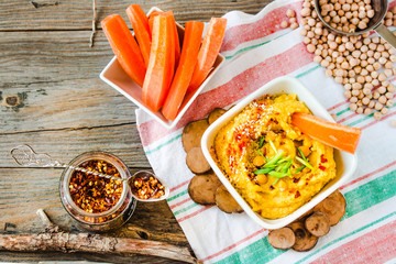 Traditional Middle east appetizer.Hummus with sesame, tahini, hot pepper and greens on a rustic...