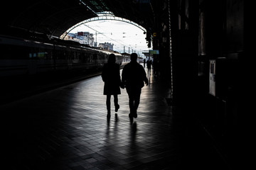 Silhouette of passengers in a train station.