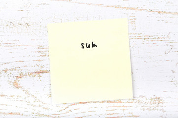 Yellow sticky note with handwritten text sum