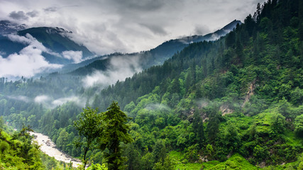 Beautiful natural scenery of  parvati river valley during monsoon passing through lush green forest of Himalayan mountains.