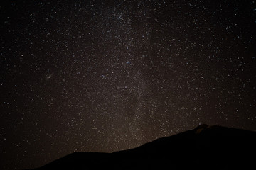 Milky Way. Space filled with stars in the sky.  Surrounded by the mountains.