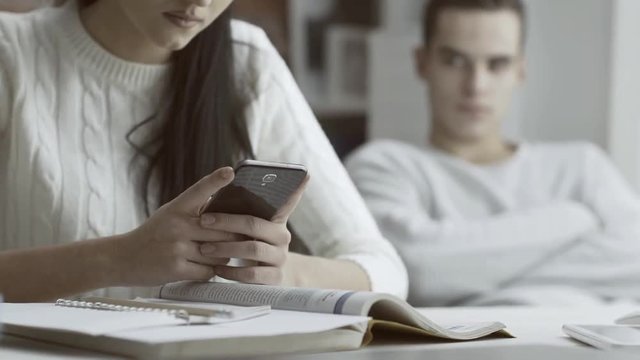 Girl chatting with her phone and ignoring her boyfriend