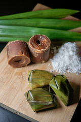 Fototapeta na wymiar Koci the malay glutinous rice ball served in banana leaf on white plate over wooden table