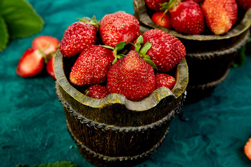 Strawberry in the bowl on a green background.