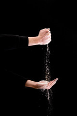 human hand hold flour isolated on black background