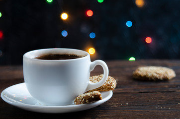 Oatmeal cookies in a metal bowl with coffee beans on old wooden background