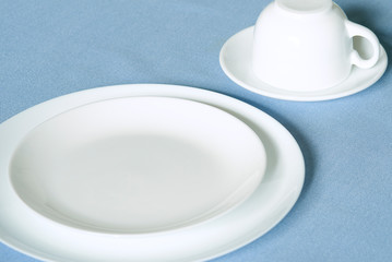 Set of white dishes on blue background