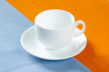 empty white cup on orange and blue background