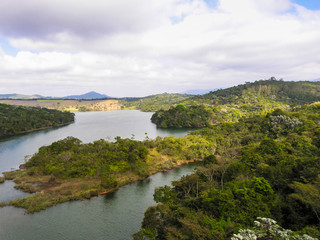 Obraz premium Rural panorama with mountains, trees, blue sky with clouds by the pond