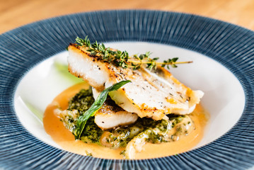 Fried fish fillet. Cod with sauce and herbs