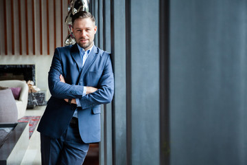 Businessman portrait. Happy confident young businessman standing arms crossed, smiling, looking at...