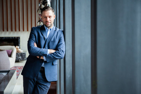 Businessman portrait. Happy confident young businessman standing arms crossed, smiling, looking at camera