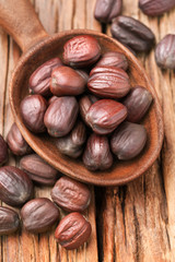 close up of dried jojoba seeds in the wooden spoon, on the wooden table