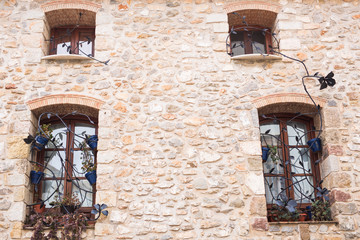 Design, architecture and exterior concept - Beautiful wrought-iron grille in the windows on stone wall