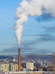 Air pollution by smoke coming out of factory chimney in the city. smoking chimney of a coal power plant.
