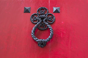 Ancient door knocker on a wooden door.