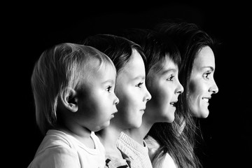 Family portrait of mother and three boys, profile picture of them all in a row, isolated on black background