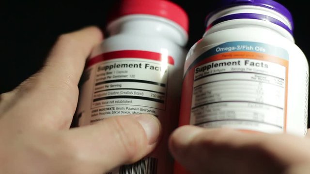 The athlete reads the food composition of sports supplements