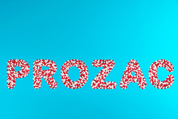 inscription prozac white and red pills on a blue background top view. concept of stress relieving antidepressants painkillers