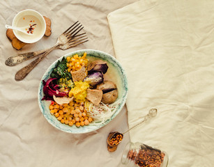 Buddha bowl recipe with roasted spinach, sweet purple potatoes, corn, beet, chickpeas and raw vegetables.