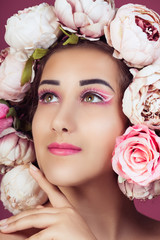 Close up portrait of beautiful young girl with pink roses flower on head and make up. Studio shot. Vertical