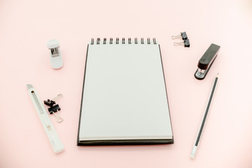  flat lay photo of workspace desk with  eyeglasses and notebook minimal style. Flat lay blog mock-up. Top view of open spiral blank notebook with pencil..