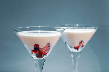 Strawberry fromage dessert in coctail glasses and lighted with artificial light. Dessert and coctail concept.