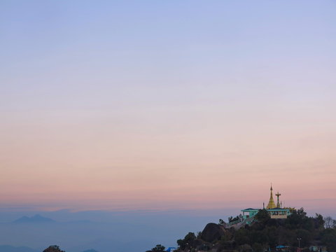 Landscape view in colorful morning sky with golden pagoda on hill in Myanmar.