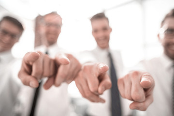 background image of a successful business team pointing to you