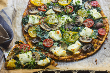 Pizza mit Spinat, Tomaten und Haloumnikäse, vegetarisch