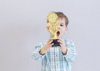 funny boy age three years old, holding in holding a trophy