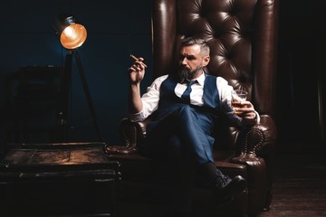 Attractive man with cigar and a glass whiskey