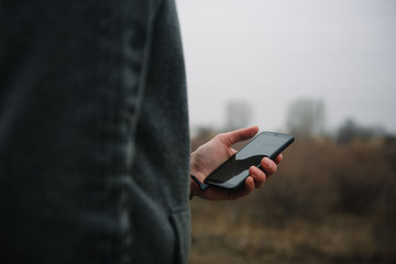 The man holds the phone in his left hand