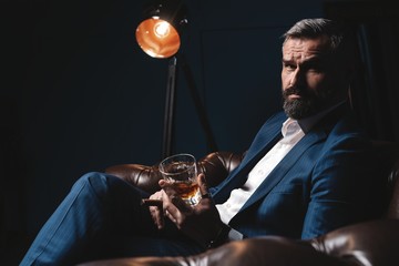 Attractive man with cigar and a glass whiskey