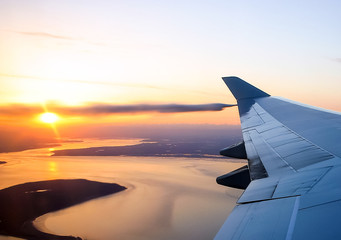 Fototapeta premium View of the sunset from the airplane porthole.
