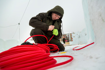 Naklejka premium The installer is installing the power cable for lighting