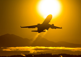 Fototapeta na wymiar Takeoff of a passenger plane on the background of a sunset.