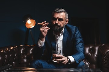 Attractive man with cigar and a glass whiskey
