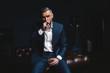 Attractive man with cigar and a glass whiskey