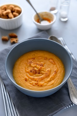 Bowl of red lentil soup on gray wooden background. Vegetarian food concept