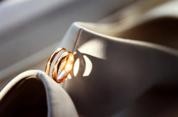 Wedding gold rings and white shoes bridge