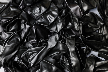 Pile of deflated black balloons on a white background. Clean pure baloon template. Logo, texture,...