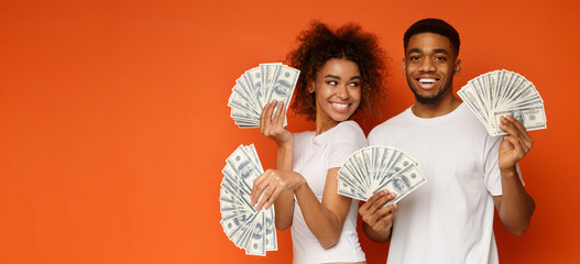 Happy couple holding bunch of money banknotes