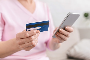 Senior woman shopping online with credit card and phone