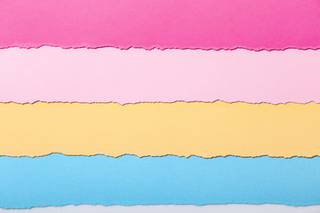 abstract background of multi-colored stripes of torn cardboard lying horizontally, top view