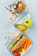 Lunch box with sandwich, fruits, vegetables, nut mix and water