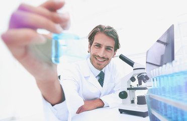 Portrait of a chemist holding a tube with liquid.