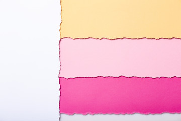 Fototapeta premium abstract background of multi-colored stripes of torn cardboard , top view,vouchers for writing reminders, concept office and business